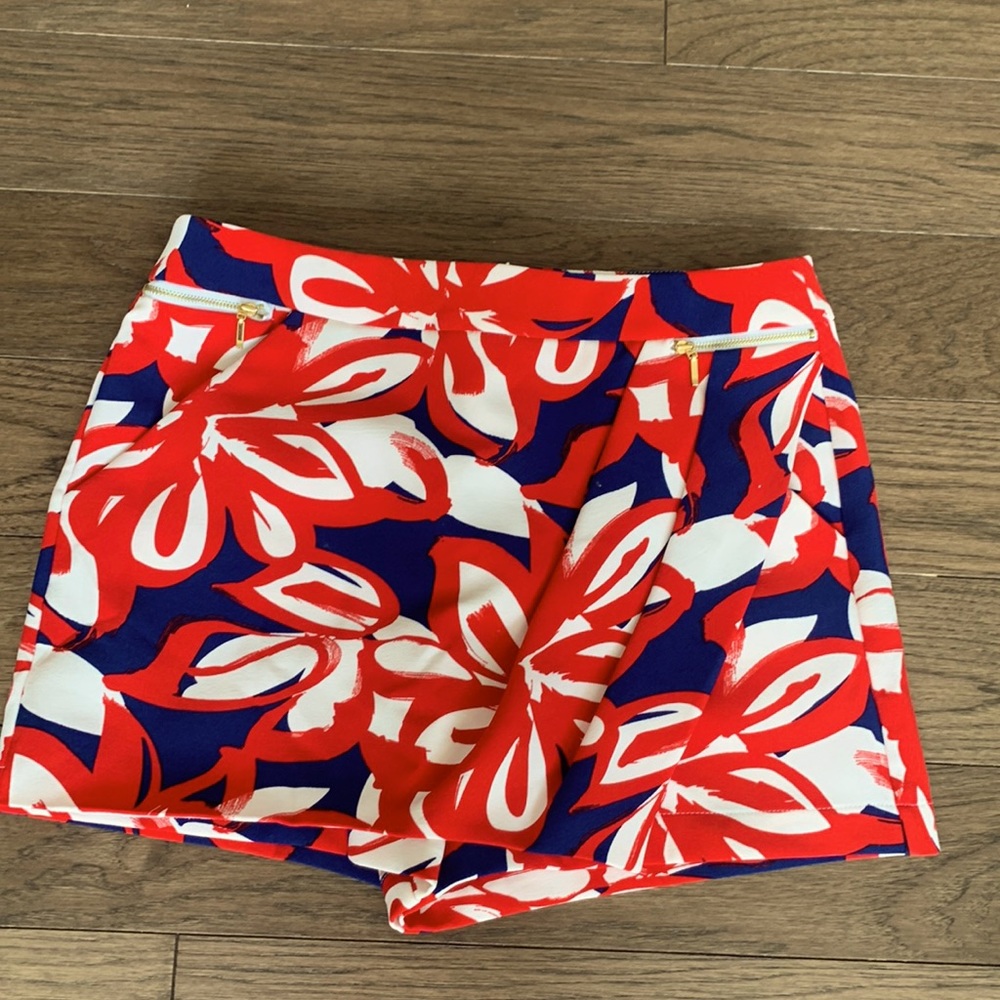 INC skort. Back zipper. Brass front pocket details. Red/blue/white floral print
